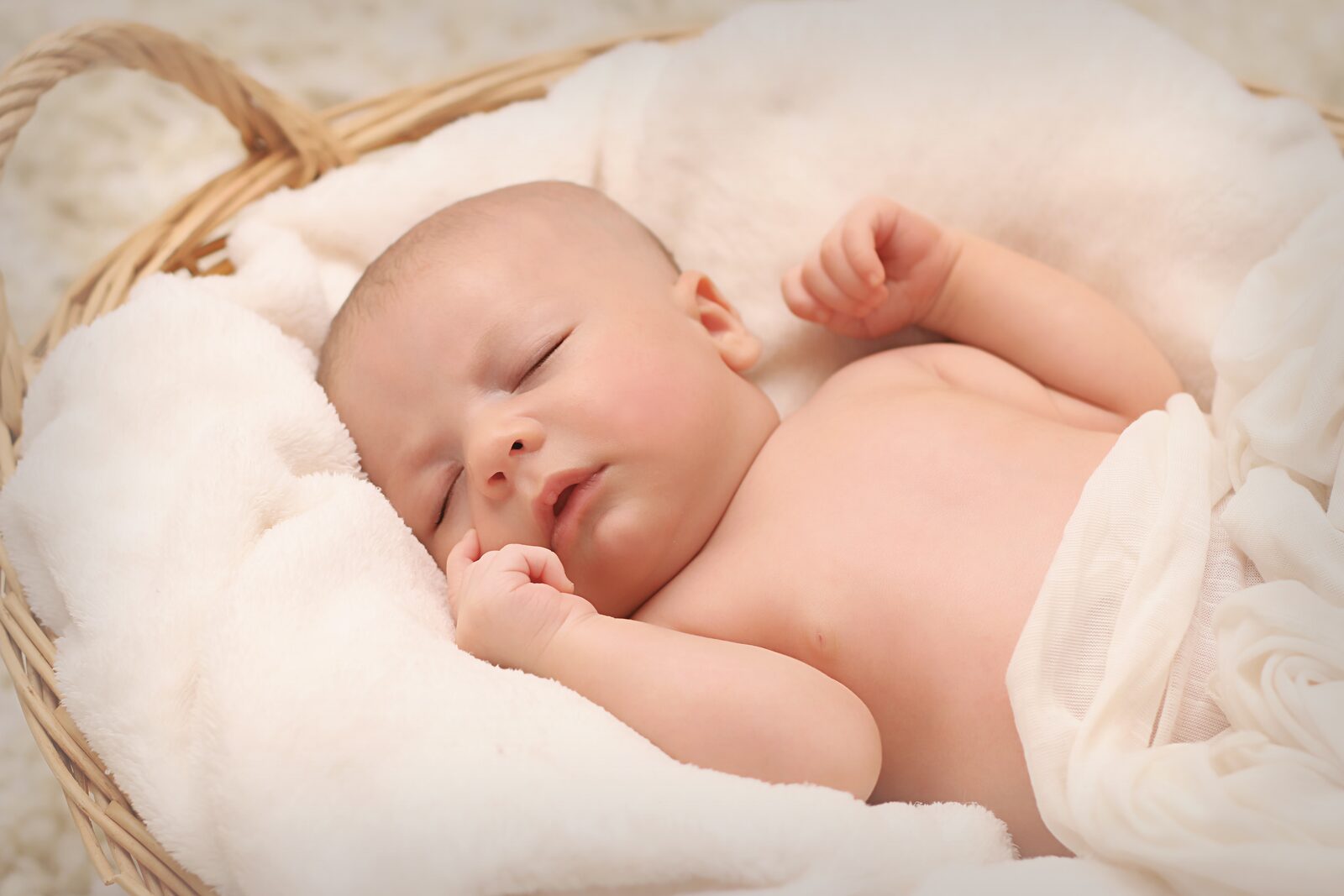 Pasgeboren baby slaapt in een mandje